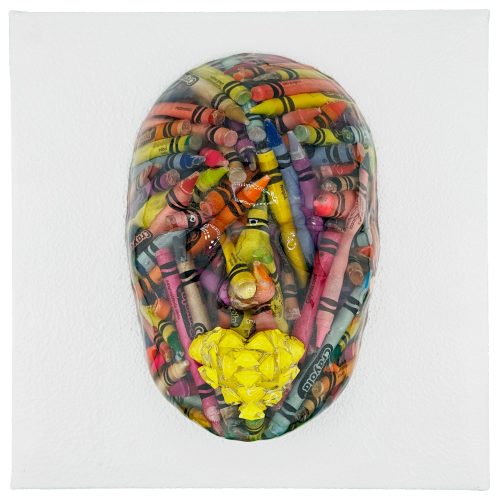 A three-dimensional face shape, perfect for e-commerce displays, is filled with colorful crayons and a bright yellow cluster at the mouth, set against a white background.