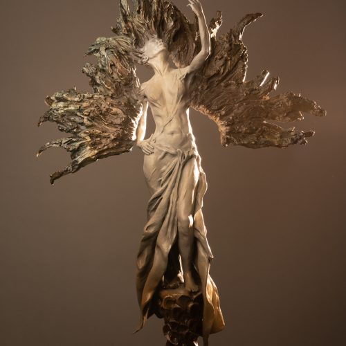 A bronze sculpture of a flowing, ethereal figure with raised arm and textured wings, standing atop a round base with organic patterns, presented in an elegant e-commerce display against a neutral background.